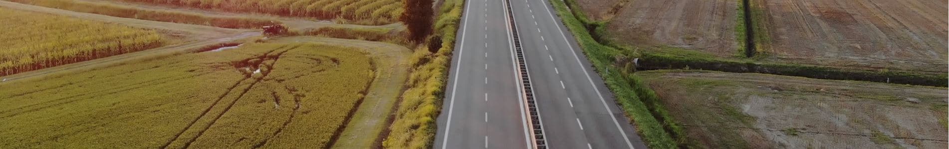 Εναέρια άποψη ευθείας εθνικής οδού ανάμεσα σε χωράφια.